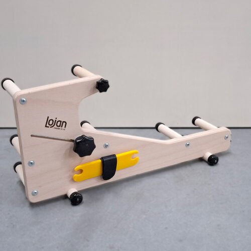 Πλάγια όψη (προφίλ) του μίνι αργαλειού Lojan Inkeltje. Το λογότυπο Lojan είναι καθαρά ορατό στο ξύλινο πάνελ, και η κίτρινη σαΐτα είναι αποθηκευμένη στην ειδική υποδοχή στο πλάι.