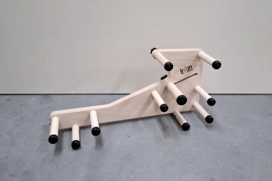 Γωνιακή φωτογραφία προϊόντος από το πίσω μέρος του μίνι αργαλειού Lojan Inkeltje, που δείχνει τη συμπαγή δομή του και τη διάταξη των πίρων χωρίς νήματα στημονιού.