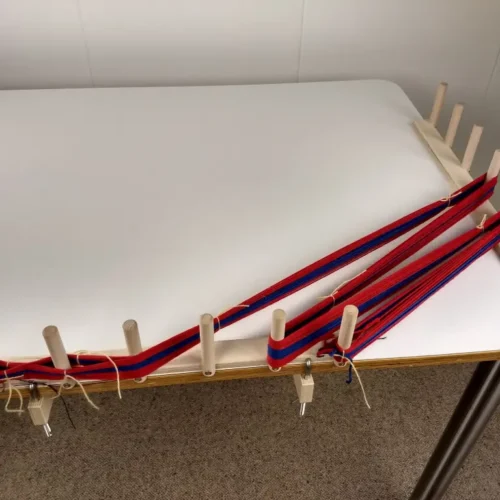 Δύο διάστρες από τη Louet με τέσσερις σφιγκτήρες τοποθετημένοι πάνω σε τραπέζι με περασμένο στημόνι