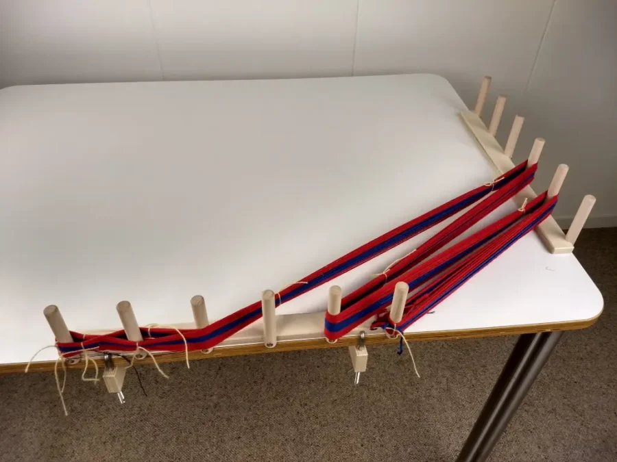 Δύο διάστρες από τη Louet με τέσσερις σφιγκτήρες τοποθετημένοι πάνω σε τραπέζι με περασμένο στημόνι